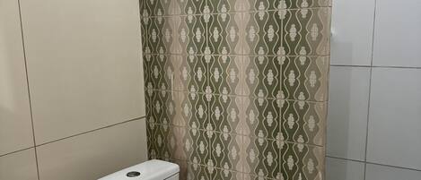 Une salle de bain comprenant des toilettes, un lavabo et un espace douche.