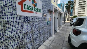 A mosaic wall with a sign for 'Casa Recife Pousada' and a white car parked nearby. - Casa Recife Pousada (Recife)