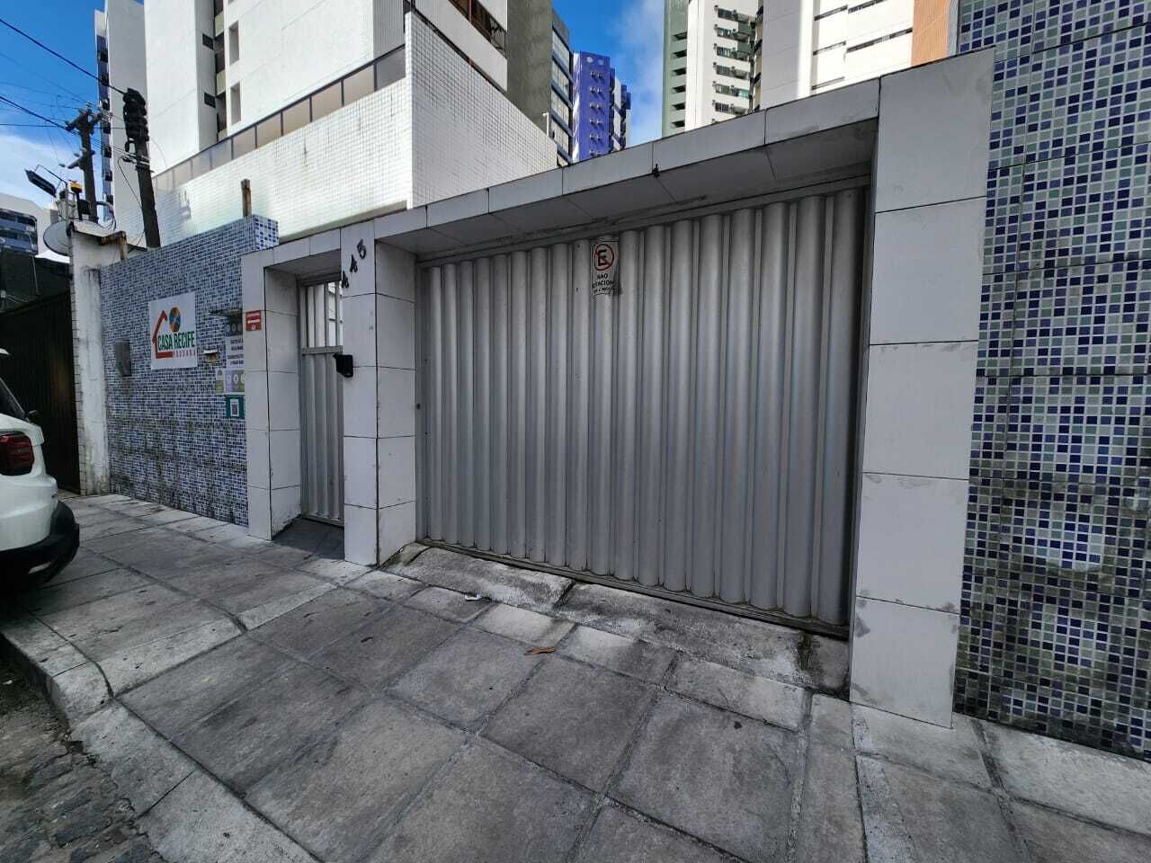 Una cancelada metálica cerrada con un cartel que indica prohibido estacionar.