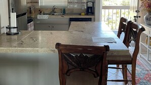 Een moderne keuken met een eethoek, met een groot schiereiland, inbouwapparatuur en uitzicht op de omgeving.