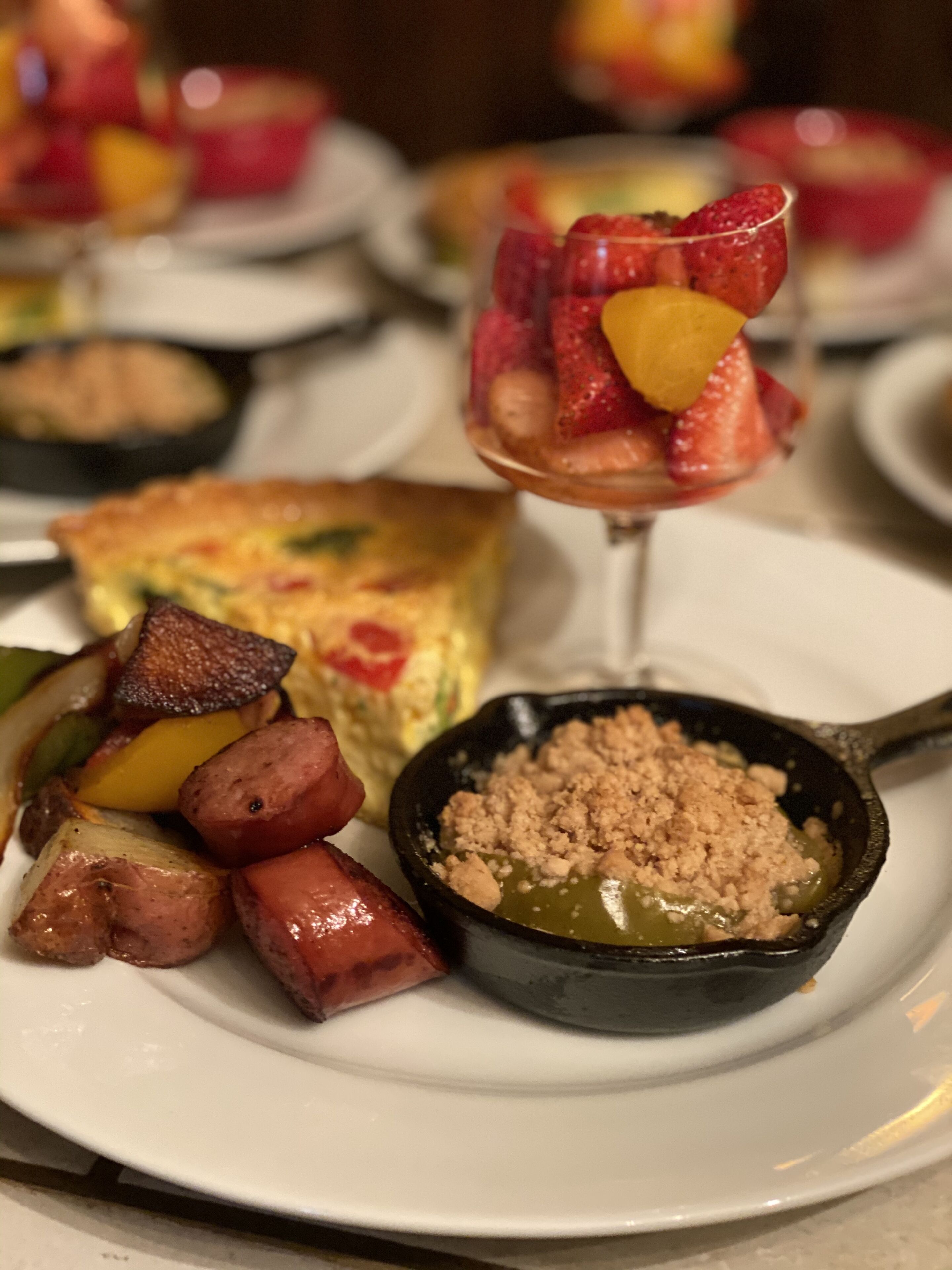 Un plato con una quiche, verduras asadas y un cuenco pequeño con cobertura desmenuzada.