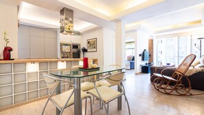 A modern kitchen with a glass dining table, stainless steel chairs, and a red vase. - SW Mendoza 20 (Málaga)