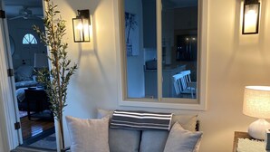 Ett vardagsrum med en soffa, ett soffbord, en lampa och en växt.