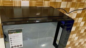 Una cocina con un microondas sobre una encimera blanca.