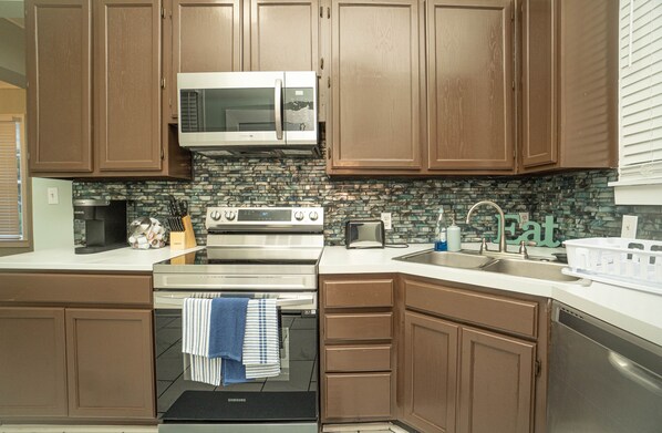 Enjoy cooking in this well-equipped kitchen with a stainless steel range hood, microwave, and dishwasher.