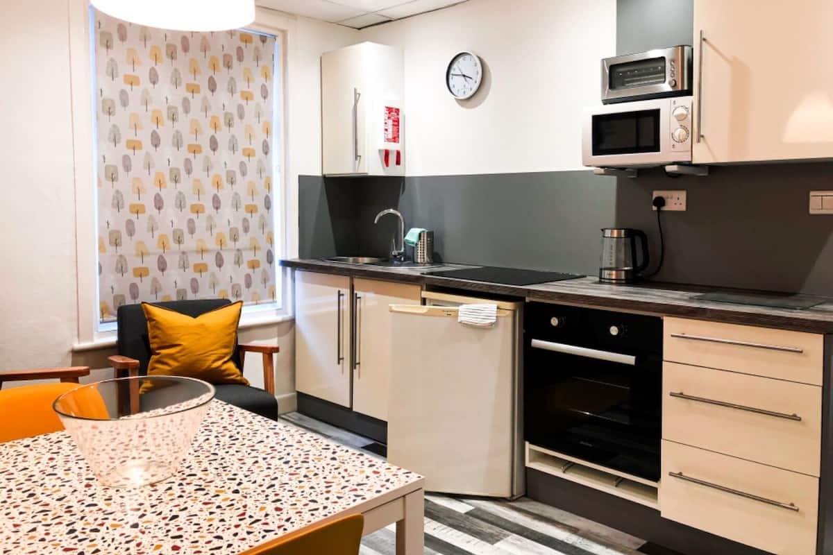 A compact kitchen with a microwave, oven, and sink.