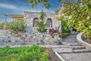 A stone building with arched windows and a staircase leading up to it.