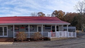 A building with a red roof, a garage, and a sign for 'Bass O'Durks Lures'. - Talkin Tackle Outfitter and Lodge (Hixson)