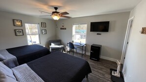 A hotel room with two beds, a desk, a chair, a television, and a ceiling fan. - Talkin Tackle Outfitter and Lodge (Hixson)