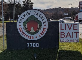Un letrero que dice 'Talkin' Tackle Outfitters + Lodge' con un letrero adicional que indica 'Se vende cebo vivo' a un lado.