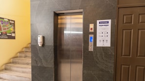 An elevator with a digital display, a hand sanitizer dispenser, and a sign with operational instructions. - Vista Terra (Chiquimula)