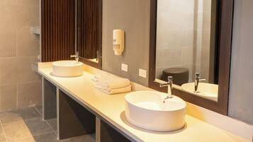 Un baño moderno con dos lavamanos, un espejo grande y un perchero para toallas.