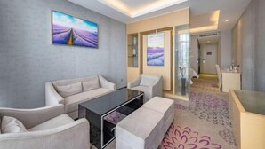 A modern living room with a sofa set, a glass coffee table, and two framed landscape paintings on the wall. - Lavande Hotel (Huizhou Yuanzhou) (Boluo)