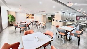 A modern restaurant with multiple dining areas, including a bar and a counter with a menu display. - Lavande Hotel (Huizhou Yuanzhou) (Boluo)