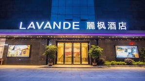 The exterior of the Lavande hotel with illuminated signage, large glass doors, and potted plants. - Lavande Hotel (Huizhou Yuanzhou) (Boluo)