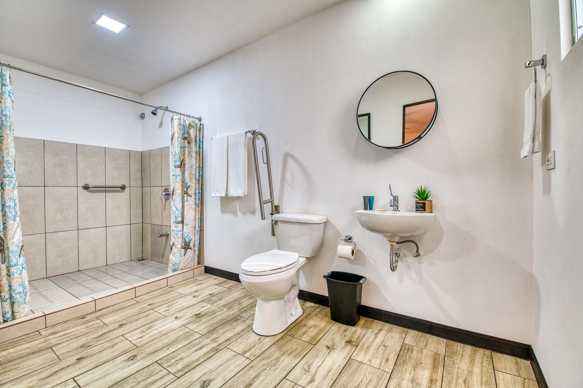 Ein modernes Badezimmer mit Dusche, Toilette, Waschbecken und Spiegel.