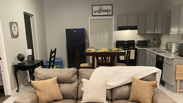 A modern living room with a brown sofa, a glass coffee table, and two black lanterns. - 3 bedroom home located within a mile from downtown (Sumter)