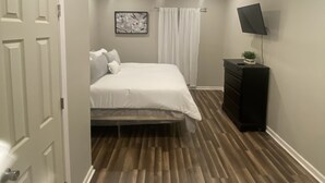 A bedroom with a bed, a dresser, a ceiling fan, and a wall-mounted TV. - 3 bedroom home located within a mile from downtown (Sumter)