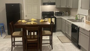 A kitchen with a dining table set for four, a black refrigerator, a stove, a microwave, and a dishwasher. - 3 bedroom home located within a mile from downtown (Sumter)