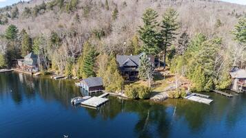 A lakeside property with multiple cabins, docks, and a docked boat.
