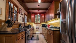 A kitchen with wooden cabinets, stainless steel appliances, and a window with a view.