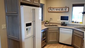Eine moderne Küche mit integriertem Kühlschrank, Wasserspender, Spüle und Geschirrspüler.