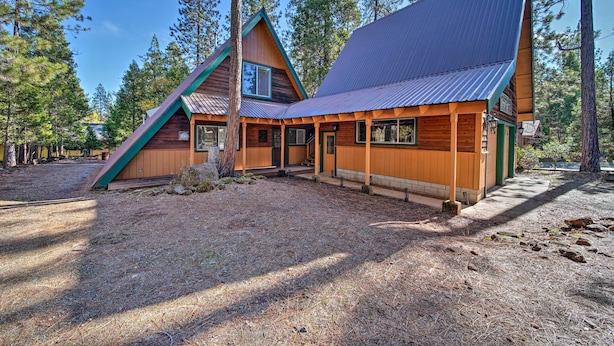 A cabin with a sloped roof, wooden exterior, and a porch area.