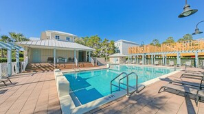 A swimming pool with steps leading into it, surrounded by a covered seating area and a building with a sloped roof. - Pet Friendly, Beach Access, GolfCart, Pool, Grill (Santa Rosa Beach)
