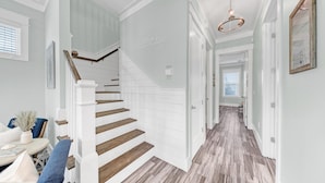 A staircase with white railings and wooden steps leading to a landing.