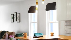 A modern kitchen with a wooden countertop, two pendant lights, and a window with a black valance. - City Oasis - Historic Blackrock- Pets and Parking (Buffalo)