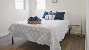 A bedroom with a bed, a bedside table, a floor lamp, and a window with a view. - City Oasis - Historic Blackrock- Pets and Parking (Buffalo)