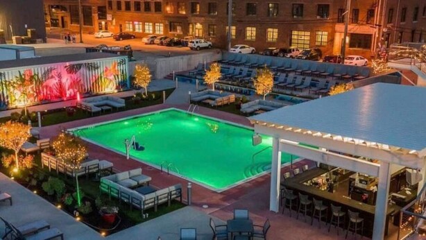 A rooftop pool area with lounge chairs and a bar, surrounded by buildings. - City Oasis - Historic Blackrock- Pets and Parking (Buffalo)