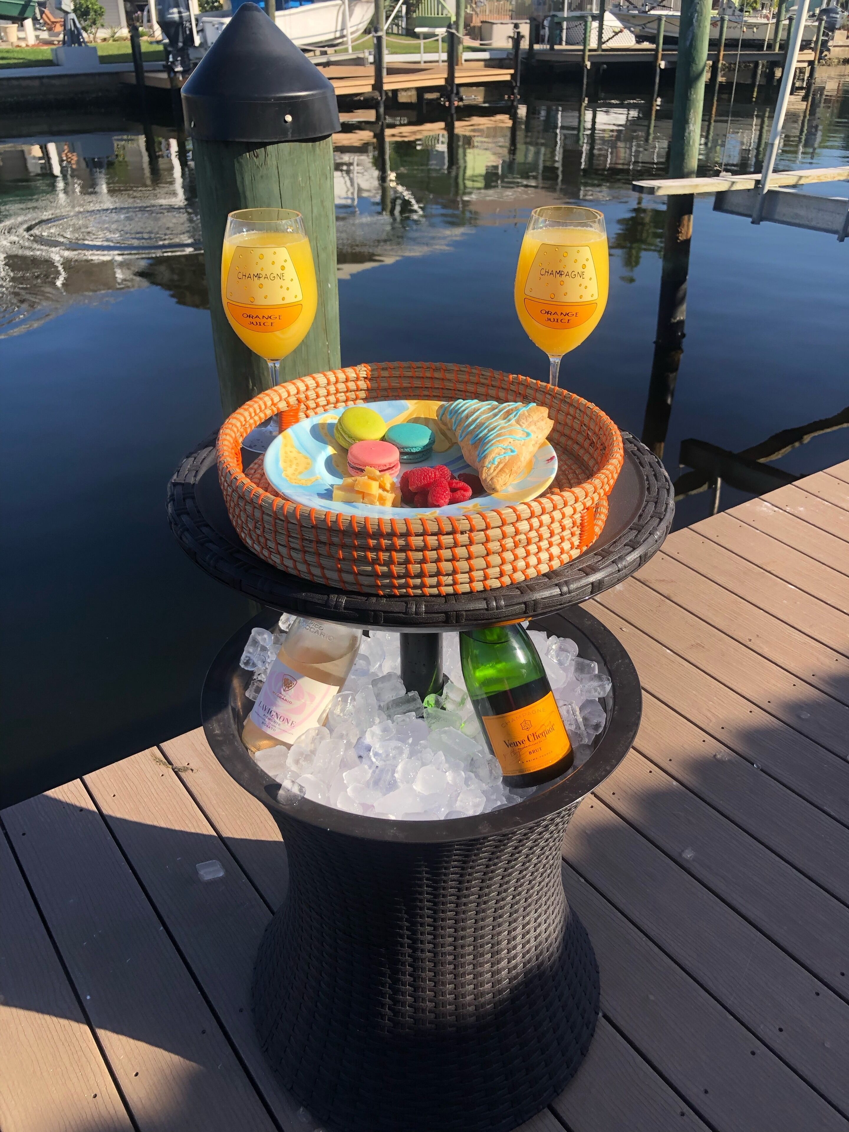 Dranken en desserts op een steiger, met een waterlichaam op de achtergrond.