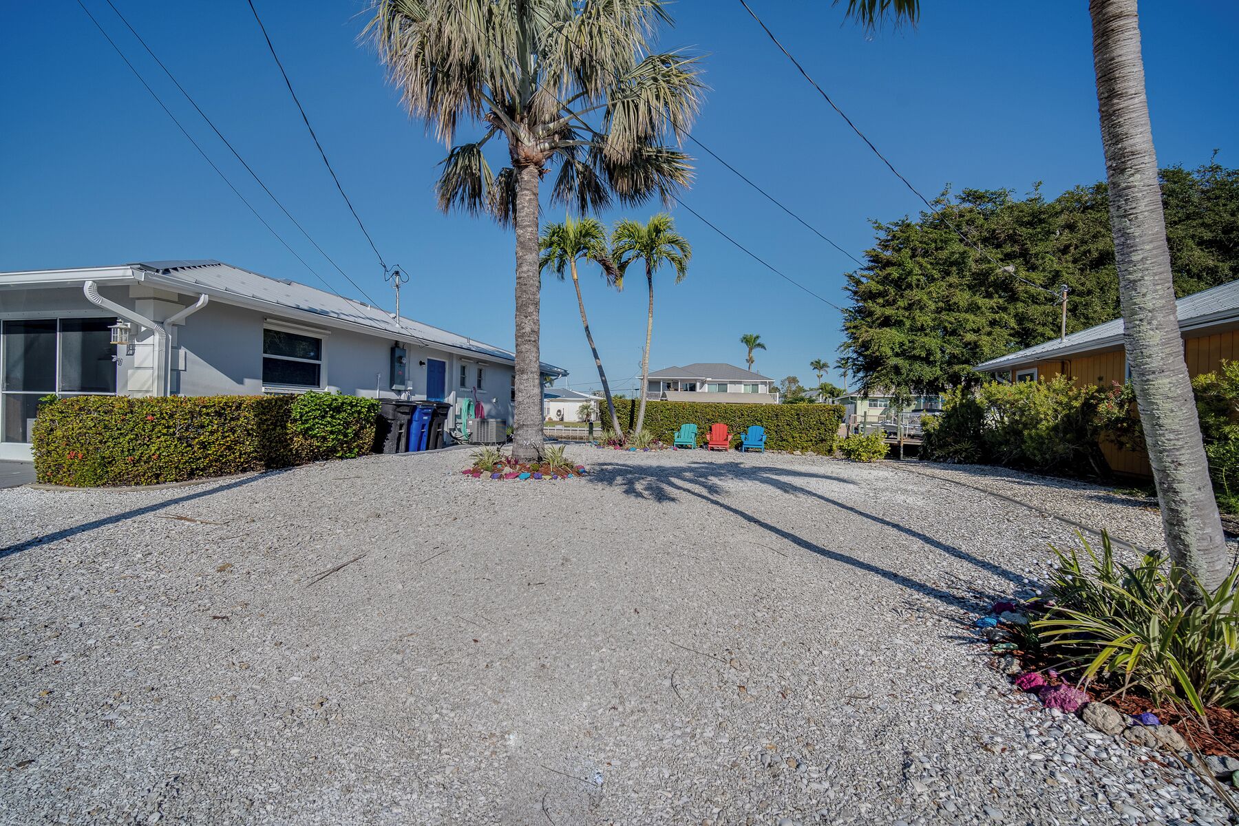 Uma área residencial com casas, ruas de cascalho e palmeiras.