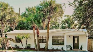 A single-story house with a white exterior, a front porch, and a mailbox. - Charming Palm Beach Home Close to Beaches (Tequesta)