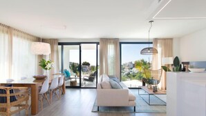 Una sala de estar moderna con sofá, comedor y cocina.