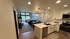A modern kitchen with white cabinets, stainless steel appliances, and a central island with a sink. - Ultimate Beaver Creek Condo: 3 BED - 3 BATH condo SLEEPS 8 with 6 beds (Avon)