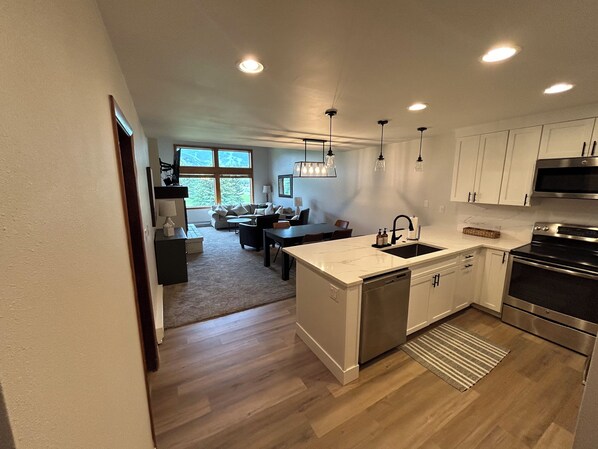 A modern kitchen with white cabinets, stainless steel appliances, and a central island with a sink. - Ultimate Beaver Creek Condo: 3 BED - 3 BATH condo SLEEPS 8 with 6 beds (Avon)