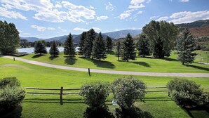A lush green landscape with a clear sky, a lake, and mountains in the background. - Ultimate Beaver Creek Condo: 3 BED - 3 BATH condo SLEEPS 8 with 6 beds (Avon)