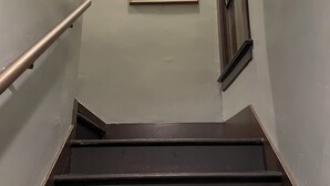 A staircase with a handrail and a framed picture of Edward Gonzales on the wall. - Spacious 1-bedroom in Oakland with AC (Oakland)