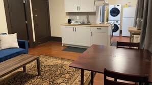 A compact living space with a kitchenette, a dining area, and a sofa. - Spacious 1-bedroom in Oakland with AC (Oakland)
