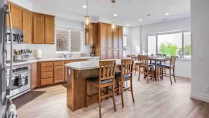 Une cuisine moderne avec des meubles en bois, un îlot central et des luminaires suspendus.