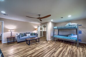 A room with a bunk bed, a sofa, a coffee table, and a ceiling fan. - Ponderosa Country Haus Prd 2495 2 Bedroom Home by RedAwning (New Braunfels)
