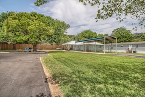 A residential area with a house, a covered patio, and a grassy lawn. - Ponderosa Country Haus Prd 2495 2 Bedroom Home by RedAwning (New Braunfels)