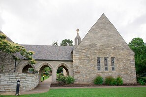 A stone building with a triangular roof and arched passageways.