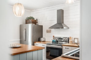 A modern kitchen with a stainless steel refrigerator, a built-in oven, and a range hood.