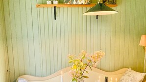 A dining table with candles, a bottle of champagne, and a vase with flowers.