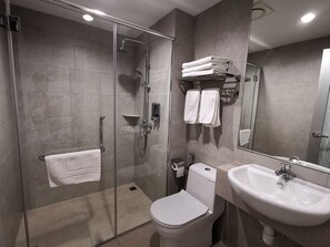 A modern bathroom with a glass-enclosed shower, a toilet, a sink, and a towel rack. - Veno Hotel (George Town)