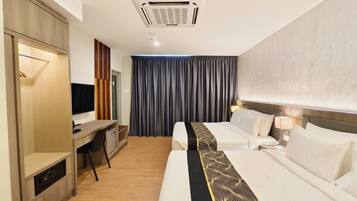 A hotel room with a bed, a desk, a TV, a wardrobe, and a curtain.