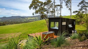 A wooden cabin with a hot tub and a view of a green valley. - Burroo at Kangaroo Valley - Perfect Views - Outdoor Bath (Barrengarry)